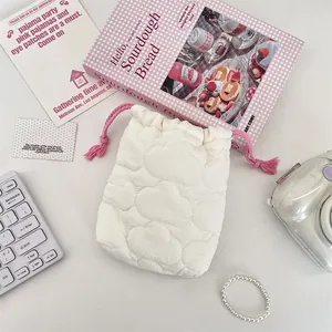 Close-up of the white cloud-quilted fabric and pink drawstring on a camera storage pouch.