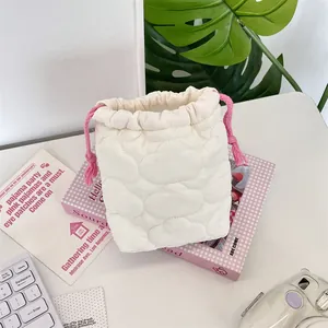 Close-up of soft quilted cotton camera pouch with pink drawstring in a lifestyle setting