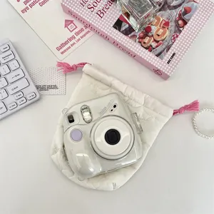 Detailed view of white quilted camera storage pouch with soft padding and pink tassels