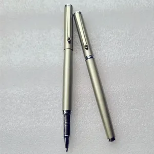 Close-up of champagne gold metal ballpoint pens with a sparkling rhinestone on the clip.
