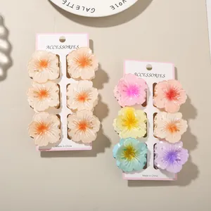 Detailed close-up of colorful frangipani flower hair claw clips on white cards