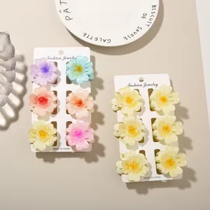 Set of colorful and yellow frangipani flower hair claw clips on display cards.