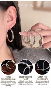 Détail rapproché de boucles d'oreilles créoles minimalistes avec finition miroir et fermoir