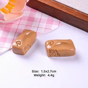 Detailed view of miniature resin chocolate charms showing size 1.5x2.7cm and weight 4.4g
