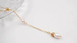 Detail shot of elegant adjustable freshwater pearl long necklace with gold chain