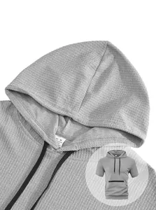 Detail of grey waffle knit hooded T-shirt showing fabric texture and tag