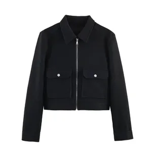 Détail d'une veste courte en tweed noir avec poches poitrine et fermeture éclair