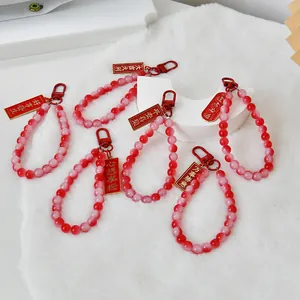 Detailed view of red gradient beaded keychains with Chinese blessing tags for bags