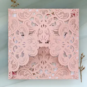 Detailed view of pink laser-cut lace floral pattern on elegant wedding invitation