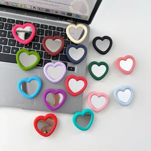 Vibrant multi-color heart-shaped silicone mirror phone grips displayed on a laptop
