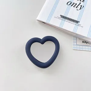 Macro view of dark blue silicone heart mirror phone socket with folding stand