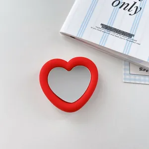 Close-up shot showing the red silicone heart-shaped phone grip and integrated mirror detail.