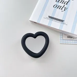Detail view of heart-shaped silicone phone socket with integrated mirror in black