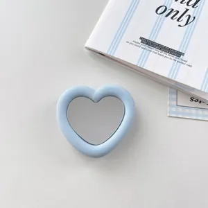 Close-up detail of a blue silicone heart-shaped mirror phone grip for smartphones