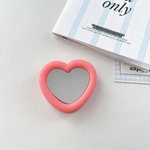 Macro view of pink heart-shaped silicone phone grip featuring a clear mirror surface