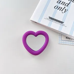 Close-up of heart-shaped purple silicone phone grip featuring a centered mirror