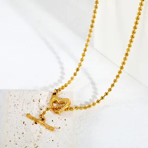 Gros plan détaillé du collier coeur doré en acier inoxydable sur une pierre