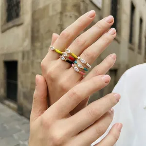 Hand modeling set of six colorful enamel rings with sparkling teardrop crystals
