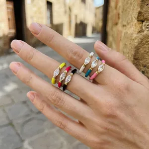 Close-up of vibrant colorful enamel stackable rings featuring marquise stones worn on fingers