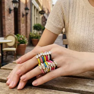 Close-up of colorful enamel teardrop rings with cubic zirconia stones worn on a hand