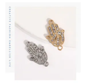 Detailed close-up of gold and silver Hamsa hand charms with sparkling rhinestones