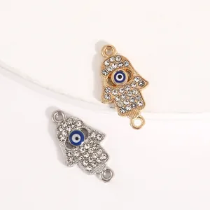 Pair of gold and silver Hamsa hand alloy charms with sparkling crystals and blue evil eye detail