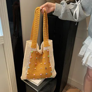 Detailed view of hand-knitted mesh tote bag with vibrant colorful beads decoration