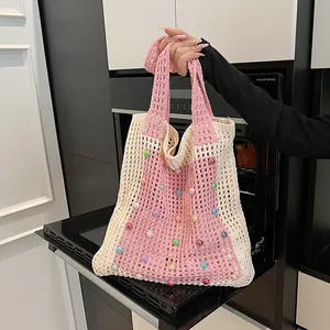 Detailed macro view of colorful pearl beads on a pink and beige crochet mesh bag