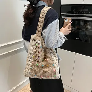 Detailed view of a handmade crochet tote bag decorated with vibrant colorful beads