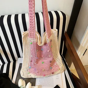 Detailed view of handmade knitted shoulder bag with colorful beads and hollow-out design