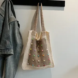 Detailed view of cream and brown knitted mesh shoulder bag with colorful bead accents