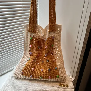 Detail shot of a hollow knit shoulder bag featuring vibrant colorful bead decorations