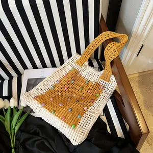 Detail view of a handmade hollow crochet knit tote bag with colorful bead accents