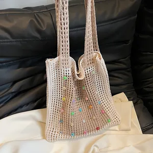 Detail view of hollow crochet tote bag with vibrant colorful beads decoration.