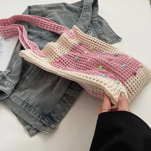 Detailed view of pink and beige knitted tote bag featuring colorful bead embellishments