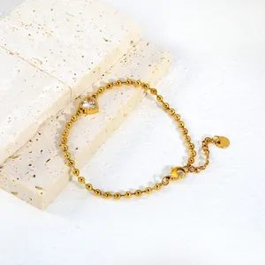Vue détaillée d'un bracelet à billes plaqué or orné d'un zircon étincelant en forme de cœur