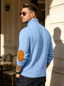Back view of a man in a light blue cable knit turtleneck sweater with elbow patches