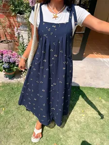 Detail of a navy blue floral print plus size summer overall dress for women in garden