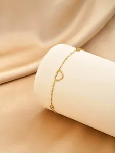 Détail du collier en acier doré avec pendentif cœur évidé et pierres de zircon.