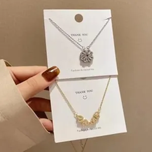 Detailed view of silver and gold clover magnetic heart necklaces on display cards