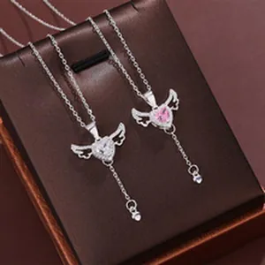 Detailed view of angel wing heart necklaces with pink and clear stones