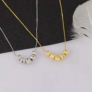 Detail of two elegant necklaces featuring silver and gold textured beads on thin chains