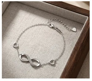 Detailed macro view of S925 sterling silver infinity heart bracelet inside wooden box
