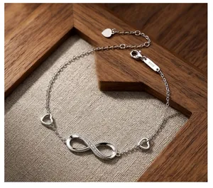 Elegant detail of S925 sterling silver infinity symbol and heart charm bracelet