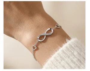 Detailed view of elegant S925 sterling silver infinity and heart bracelet on wrist