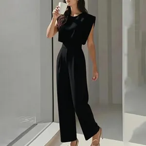Vollansicht eines eleganten schwarzen Outfits mit Polstern und modischer weiter Hose