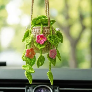 Close-up of handmade crochet plant car mirror hanging with pink flowers