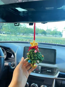 Detailed close-up of a charming hand-knitted Christmas tree car mirror hanging ornament
