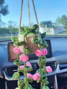 Handmade crochet hanging plant with pink roses for car rearview mirror decoration.