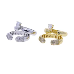 Close-up of elegant gold and silver open rings featuring pavé settings and pear zircon stones.